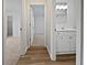 Bathroom with a mirror, a vanity, wood floors, and a view to the hall and bedroom at 3524 Cessna St, Port Charlotte, FL 33948