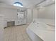 Bathroom featuring a soaking tub, a vanity, a large mirror, and ceramic tile flooring at 3524 Cessna St, Port Charlotte, FL 33948