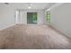 Large bedroom with neutral carpet, ceiling fan, big window, and access to the outside at 3524 Cessna St, Port Charlotte, FL 33948
