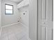 Bright laundry room featuring tile flooring, built-in storage, and window for natural light at 3524 Cessna St, Port Charlotte, FL 33948