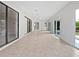 Large patio with tile flooring, sliding doors to home interior and lush greenery outside at 3524 Cessna St, Port Charlotte, FL 33948