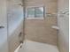 Bathroom with stylish tile surround, shower, and window for natural light at 4409 W Leila Ave, Tampa, FL 33616
