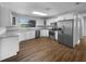 Bright kitchen features stainless appliances, white cabinets, granite counters, and wood floors at 4409 W Leila Ave, Tampa, FL 33616