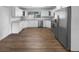 Bright kitchen features stainless appliances, white cabinets, granite counters, and wood floors at 4409 W Leila Ave, Tampa, FL 33616