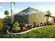 Landscaped backyard oasis with lush plants and a screened enclosure at 4202 Perch Cir, Port Charlotte, FL 33948