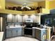 Modern kitchen with gray cabinets, stainless steel appliances, and a breakfast bar at 4202 Perch Cir, Port Charlotte, FL 33948