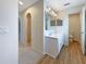 Bathroom with double vanity, wood-look flooring and an arched doorway leading to closet at 3444 97Th E Ln, Palmetto, FL 34221