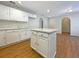 Kitchen with island, white cabinets, granite countertops, and laminate floors at 3444 97Th E Ln, Palmetto, FL 34221