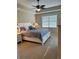A spacious bedroom featuring a large bed, neutral carpet, and a ceiling fan at 23598 Awabuki Dr # 102, Venice, FL 34293
