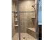 A close up of bathroom tiled shower and a built in seat at 23598 Awabuki Dr # 102, Venice, FL 34293