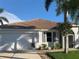 White house with brown tile roof, two-car garage, and palm trees at 17274 Asmara Ct, Punta Gorda, FL 33955