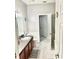 Bathroom with tiled floor, shower, and vanity with wood cabinets at 17274 Asmara Ct, Punta Gorda, FL 33955