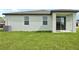 Home's backyard featuring a well-maintained lawn and sliding glass doors at 145 Lazy Shore Dr, Nokomis, FL 34275