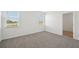 Bedroom featuring neutral carpet and two bright windows at 145 Lazy Shore Dr, Nokomis, FL 34275