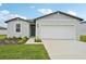 Charming single-Gathering home featuring a well-manicured lawn, green front door, and two-car garage at 145 Lazy Shore Dr, Nokomis, FL 34275