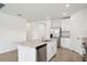 Modern open-concept kitchen featuring a center island with a sink, stainless steel appliances, and white cabinetry at 145 Lazy Shore Dr, Nokomis, FL 34275