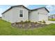 Landscaped flower bed with a view of the house with green grass and green front door at 145 Lazy Shore Dr, Nokomis, FL 34275