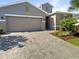 Gray house with paver driveway and landscaping at 12545 Ryegrass Loop, Parrish, FL 34219