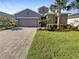 Two-story house with gray siding, paver driveway, and landscaped yard at 12545 Ryegrass Loop, Parrish, FL 34219