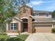 Two-story house with stone accents and a two-car garage at 7904 Camden Woods Dr, Tampa, FL 33619