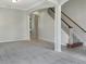 Open living room with carpeted floors and a staircase at 7904 Camden Woods Dr, Tampa, FL 33619