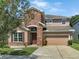 Two-story house with stone accents and a two-car garage at 7904 Camden Woods Dr, Tampa, FL 33619