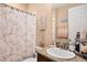Clean bathroom with floral shower curtain and granite vanity at 9111 Isabella Cir, Parrish, FL 34219
