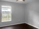 Simple bedroom with dark hardwood floors and a window at 11158 Golden Silence Dr, Riverview, FL 33579