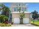 Tan three-story house, two car garage, and tropical landscaping at 1340 Apollo Beach S Blvd, Apollo Beach, FL 33572