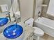 Bathroom with blue glass sink, white bathtub and tile flooring at 1340 Apollo Beach S Blvd, Apollo Beach, FL 33572
