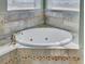 Relaxing bathroom with a large corner jacuzzi tub and updated tile at 1340 Apollo Beach S Blvd, Apollo Beach, FL 33572