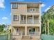 Tan two-story house with a balcony, private patio, and lush landscaping at 1340 Apollo Beach S Blvd, Apollo Beach, FL 33572