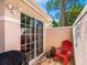 Inviting patio with red chairs and a sliding glass door leading to the interior at 5462 Chanteclaire # 65, Sarasota, FL 34235