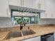 Kitchen sink with granite countertop and pass-through to living room at 5462 Chanteclaire # 65, Sarasota, FL 34235