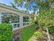 Exterior view showcases a home with arched windows, light-colored siding, and a manicured lawn at 5462 Chanteclaire # 65, Sarasota, FL 34235