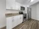 Modern kitchen features white cabinets, granite countertops, and stainless steel appliances at 1052 Longfellow Cir, Sarasota, FL 34243