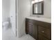 Simple bathroom with dark brown vanity and white tile at 1052 Longfellow Cir, Sarasota, FL 34243