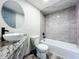 Clean bathroom with granite vanity, bathtub, and gray tile at 210 15Th E St, Bradenton, FL 34208