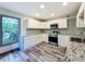 Modern kitchen with white cabinets, granite counters, and stainless steel appliances at 210 15Th E St, Bradenton, FL 34208
