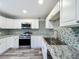 Modern kitchen with white cabinets, granite counters, and stainless steel appliances at 210 15Th E St, Bradenton, FL 34208