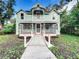 Two-story light teal home with a wrap around porch at 210 15Th E St, Bradenton, FL 34208