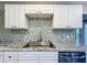 Modern kitchen sink with granite countertop and mosaic backsplash at 210 15Th E St, Bradenton, FL 34208