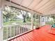 Relaxing screened porch with red painted floor and backyard view at 210 15Th E St, Bradenton, FL 34208