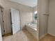 Bathroom features large soaking tub, tile floors, and window at 2302 123Rd E Pl, Parrish, FL 34219
