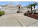 Spacious double garage with a wide concrete driveway, stone accents, and well-maintained landscaping at 2302 123Rd E Pl, Parrish, FL 34219