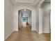 Inviting hallway with arched doorways, neutral paint, and tile flooring leading to the living area at 2302 123Rd E Pl, Parrish, FL 34219