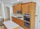 Modern kitchen featuring stainless steel appliances, double ovens, and custom wooden cabinetry at 2302 123Rd E Pl, Parrish, FL 34219