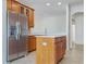 Modern kitchen featuring an island, tile floors, stainless steel refrigerator and custom wood cabinetry at 2302 123Rd E Pl, Parrish, FL 34219