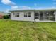 House exterior showcasing a large grassy backyard and screened patio at 8188 San Jacinto Ave, North Port, FL 34287