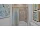 Bathroom featuring a tub with shower, tiled walls, and decorative art at 1529 Rio Vista Ter, Parrish, FL 34219